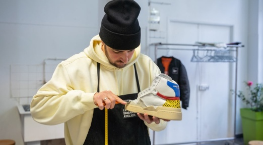 homme répare une chaussure