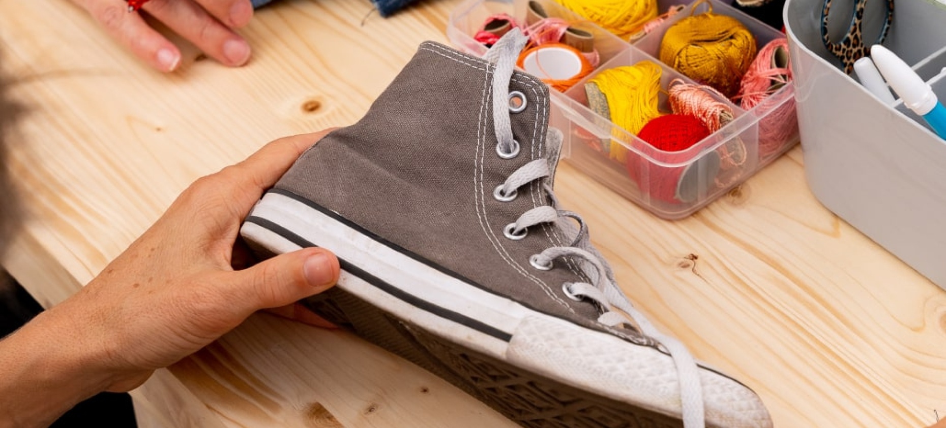 femme fait de la couture sur une chaussure en tissu