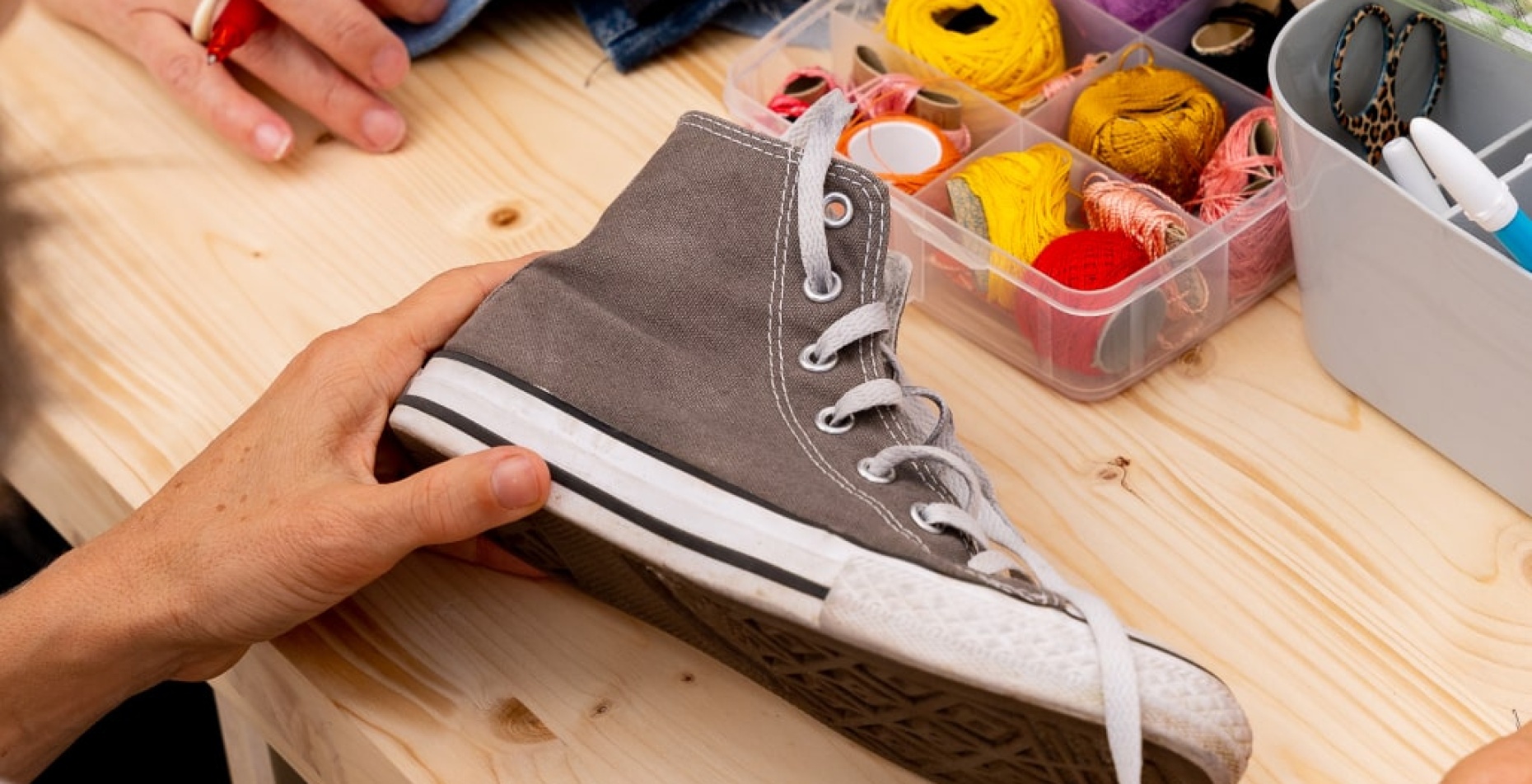 femme fait de la couture sur une chaussure en tissu