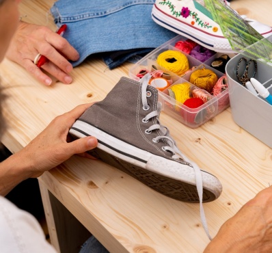 femme fait de la couture sur une chaussure en tissu