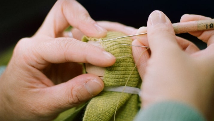 personne en train de coudreà la main
