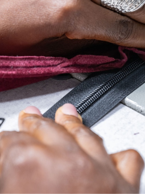 personne en train coudre un zip sur une pièce en textile