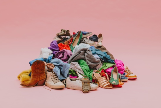 Tas de textiles colorés en bon état fond rose