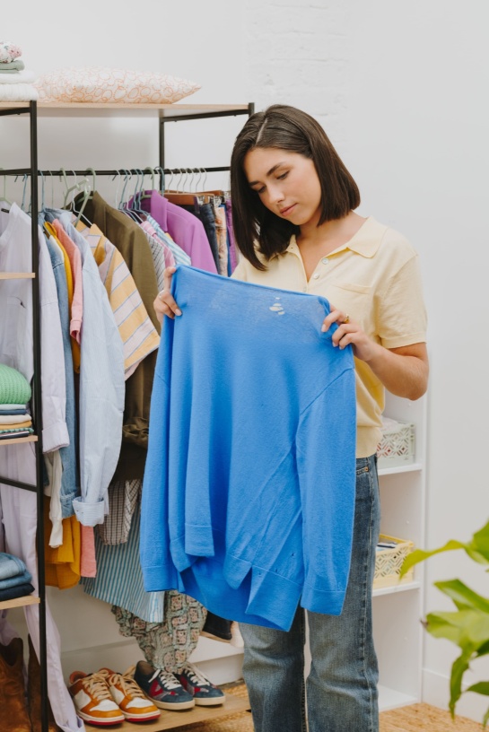Femme regardant l'état d'un pull bleu